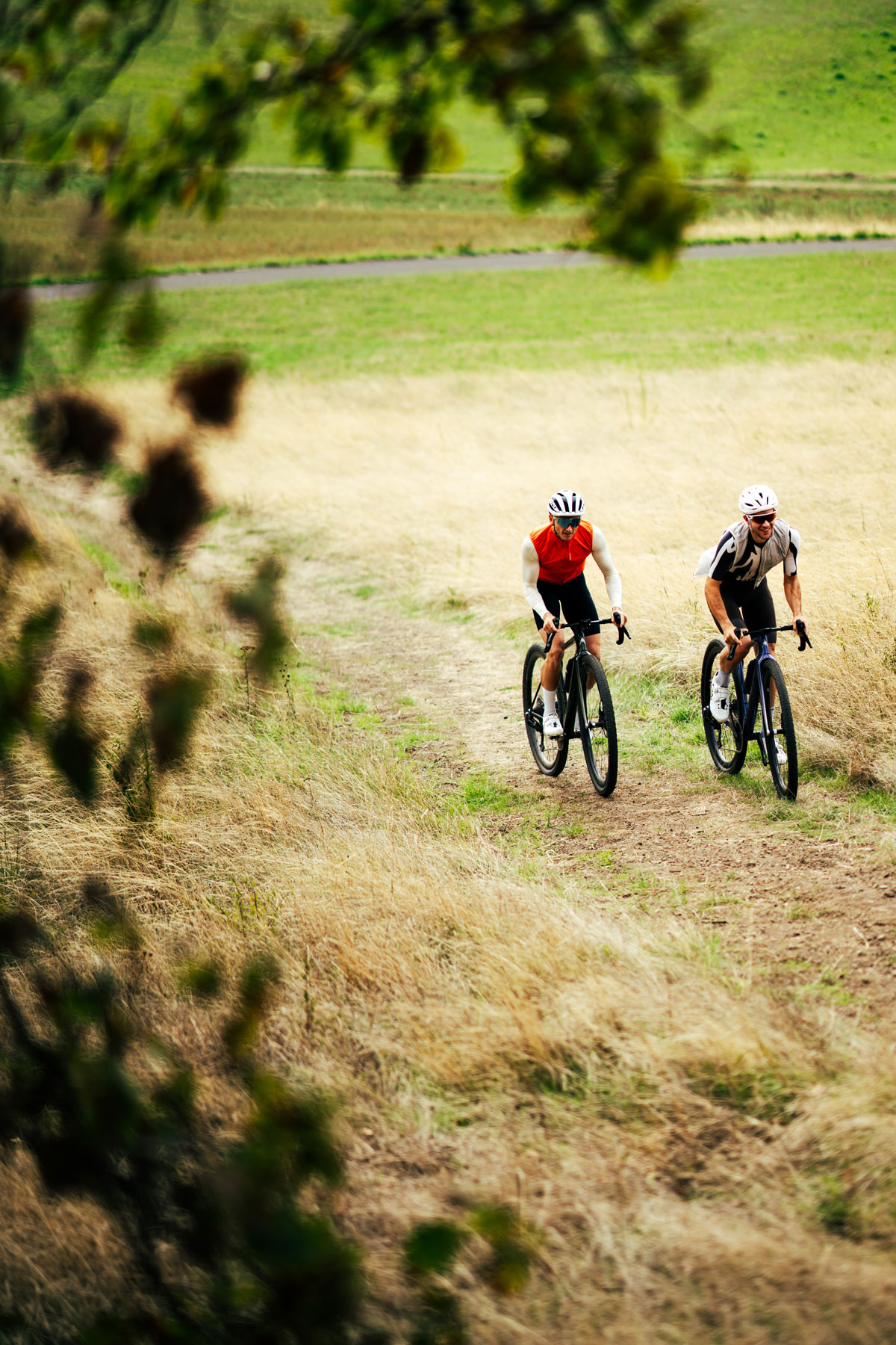 Two riders on a meadow path, shot from above